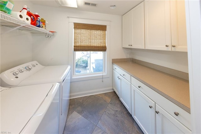 clothes washing area with cabinets and washing machine and dryer