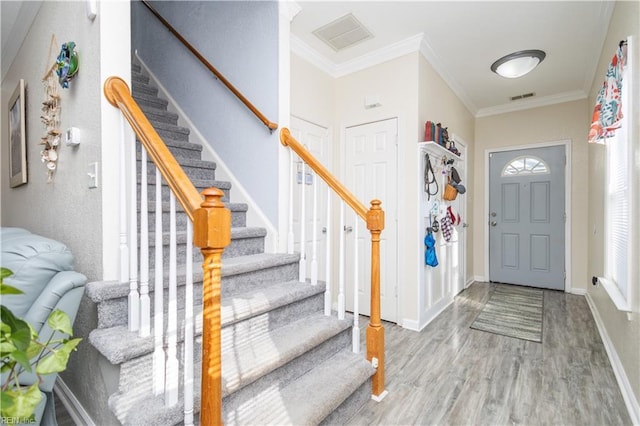 entryway featuring hardwood / wood-style floors and ornamental molding