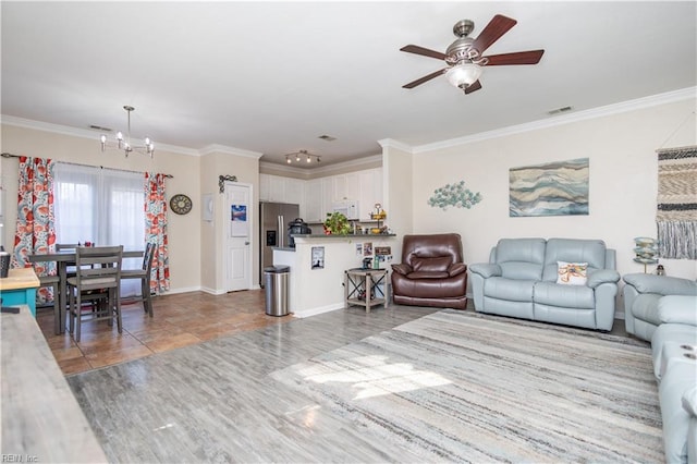 living room featuring ornamental molding, light hardwood / wood-style floors, and ceiling fan with notable chandelier