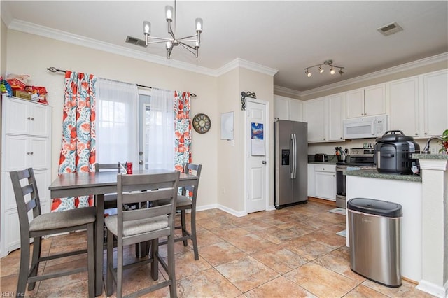 kitchen with white cabinetry, appliances with stainless steel finishes, ornamental molding, and a notable chandelier