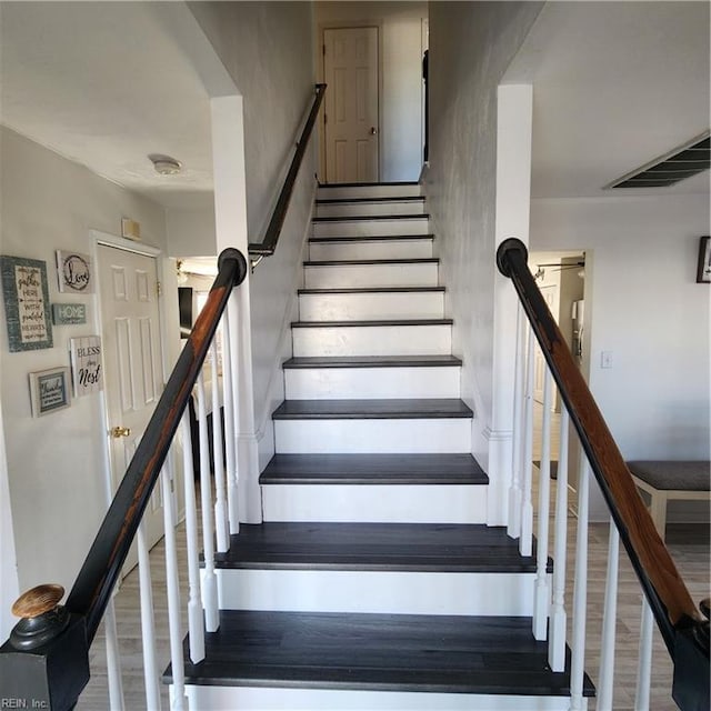 staircase with hardwood / wood-style flooring