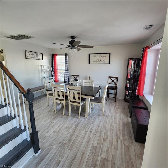 dining space with ceiling fan and light wood-type flooring