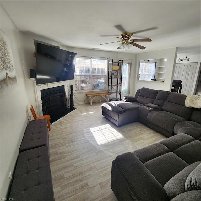 living room with light hardwood / wood-style floors and ceiling fan