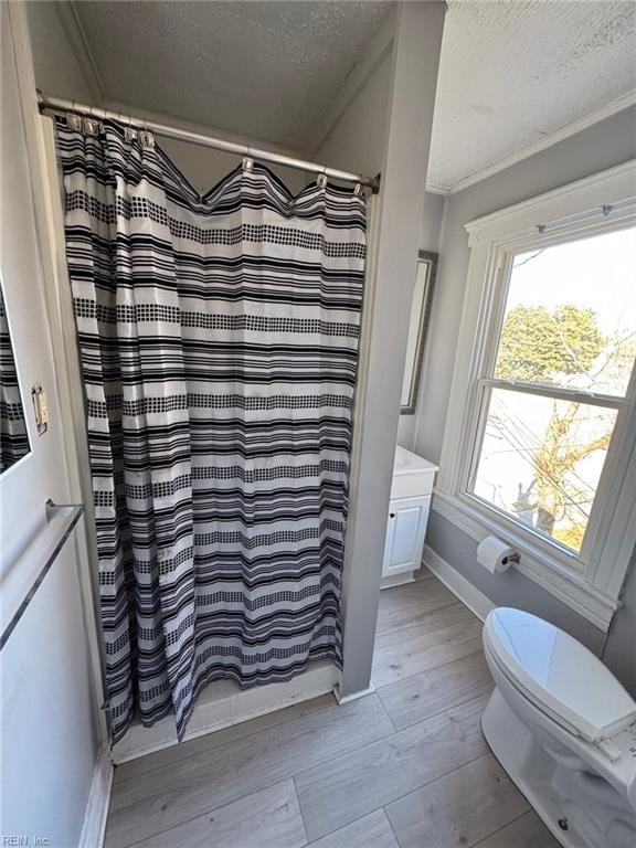 bathroom with curtained shower, hardwood / wood-style flooring, vanity, ornamental molding, and a textured ceiling