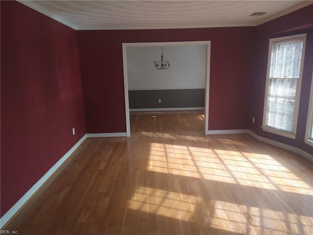 unfurnished dining area featuring hardwood / wood-style flooring, ornamental molding, and a chandelier