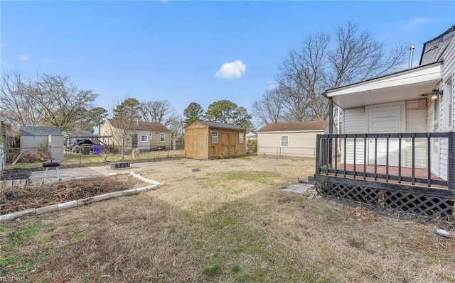 view of yard with a wooden deck and a storage unit