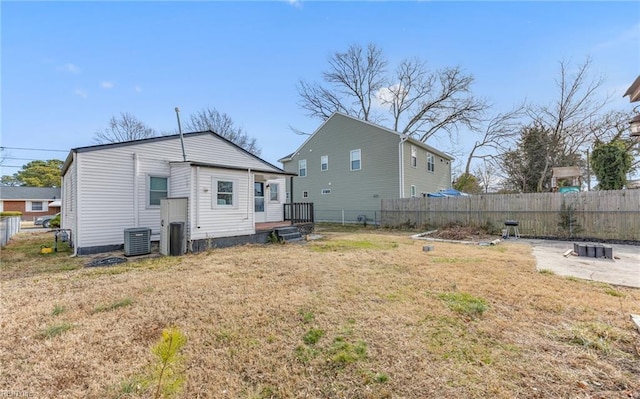 back of house with a yard and central air condition unit