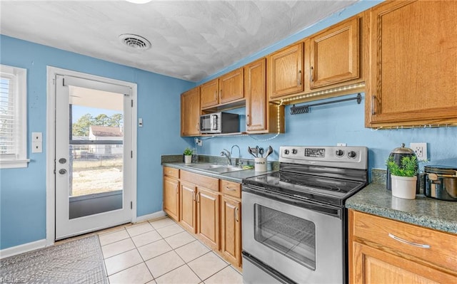 kitchen featuring light tile patterned flooring, appliances with stainless steel finishes, and sink