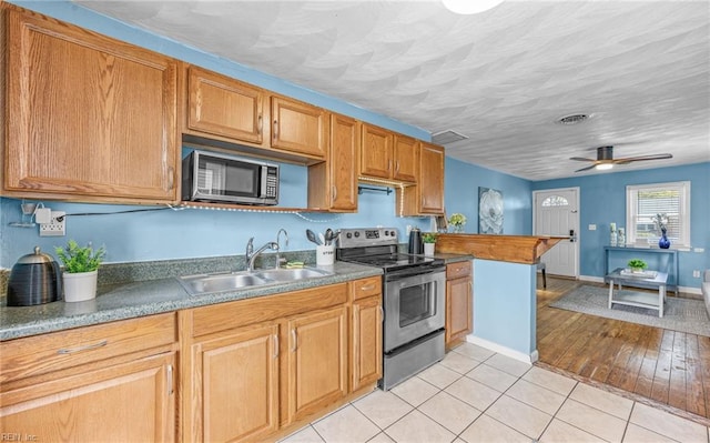 kitchen featuring sink, ceiling fan, stainless steel appliances, a textured ceiling, and light tile patterned flooring