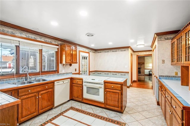 kitchen featuring sink, crown molding, tasteful backsplash, kitchen peninsula, and white appliances