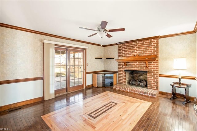 unfurnished living room featuring crown molding, ceiling fan, a fireplace, and dark hardwood / wood-style flooring