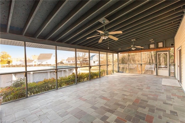 unfurnished sunroom with ceiling fan