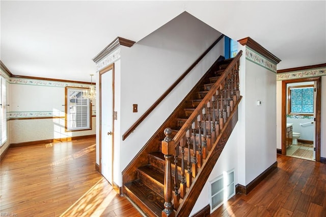 stairs with crown molding and hardwood / wood-style floors