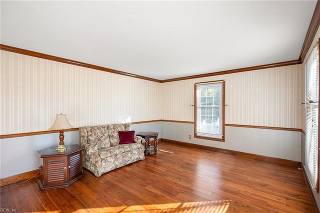 living area with crown molding and hardwood / wood-style floors