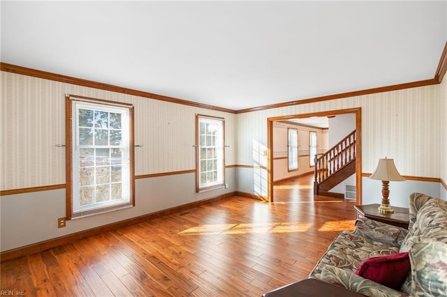 unfurnished living room with crown molding and light wood-type flooring