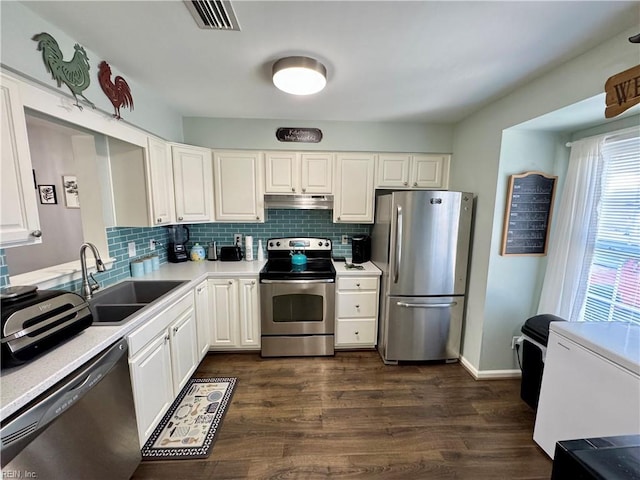 kitchen with appliances with stainless steel finishes, dark hardwood / wood-style flooring, sink, and white cabinets