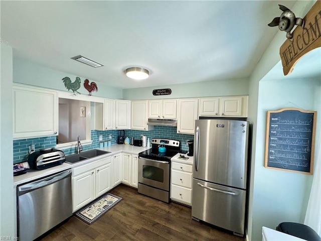 kitchen featuring tasteful backsplash, white cabinetry, sink, stainless steel appliances, and dark wood-type flooring