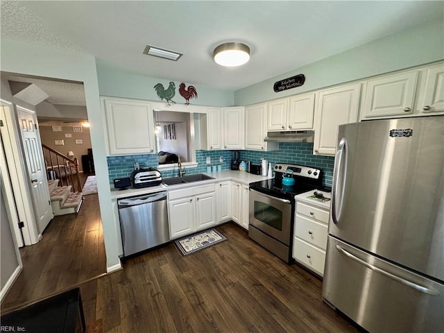 kitchen with sink, white cabinetry, tasteful backsplash, appliances with stainless steel finishes, and dark hardwood / wood-style flooring