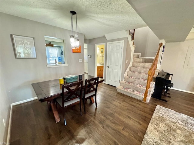 dining room featuring a textured ceiling and dark hardwood / wood-style flooring