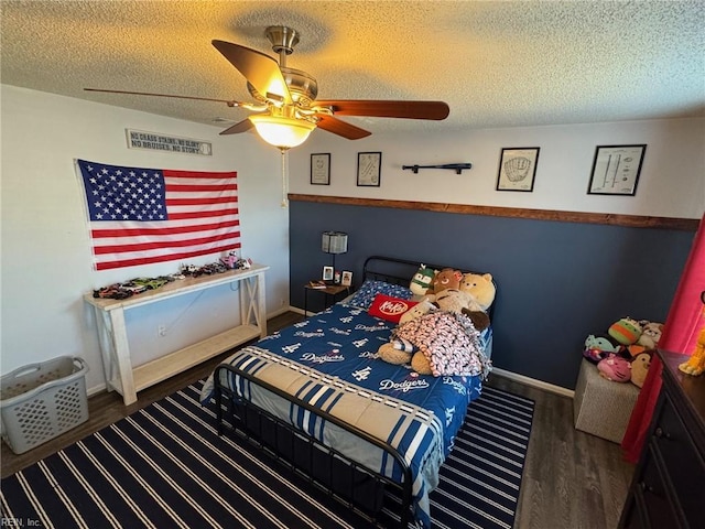 bedroom with ceiling fan, dark hardwood / wood-style floors, and a textured ceiling