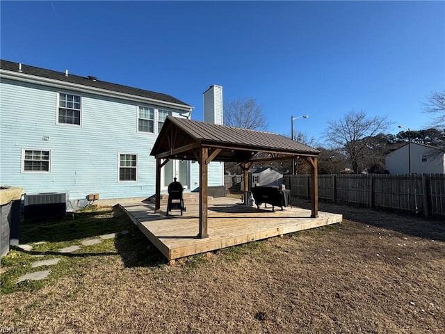 rear view of property with a gazebo, a yard, a deck, and central AC