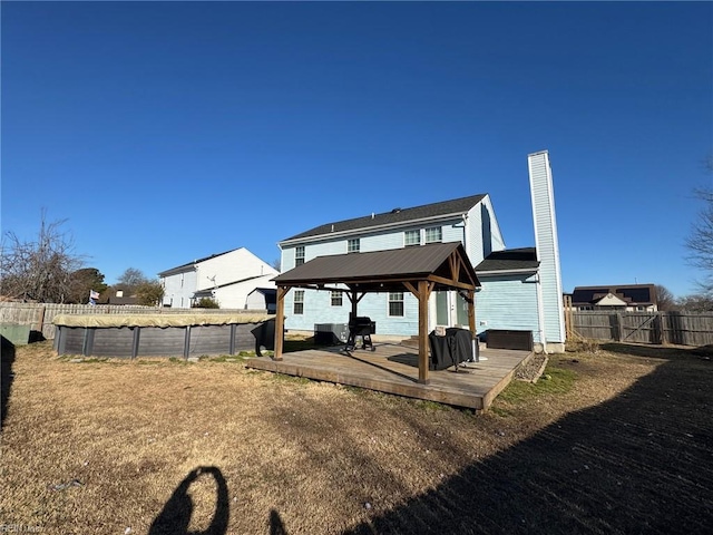 back of property with a pool side deck and a gazebo