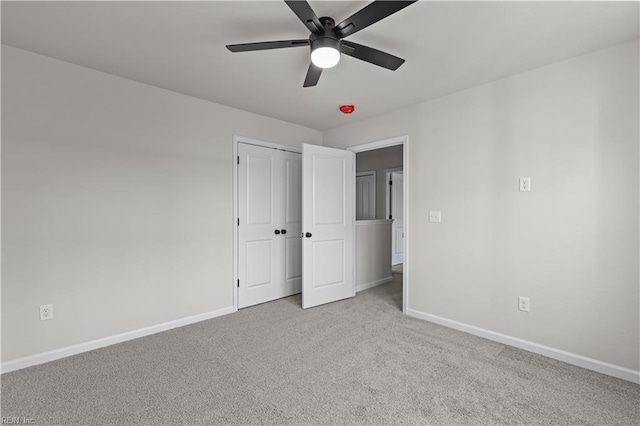 unfurnished bedroom featuring ceiling fan, a closet, and light carpet