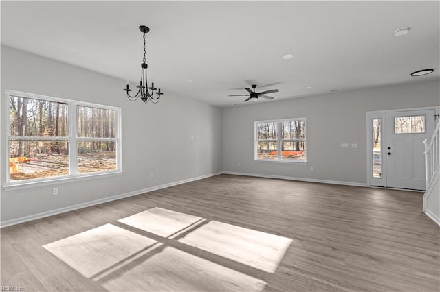 interior space with hardwood / wood-style flooring and ceiling fan with notable chandelier