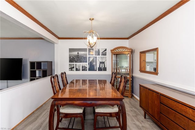 dining room featuring crown molding, light hardwood / wood-style flooring, and a notable chandelier