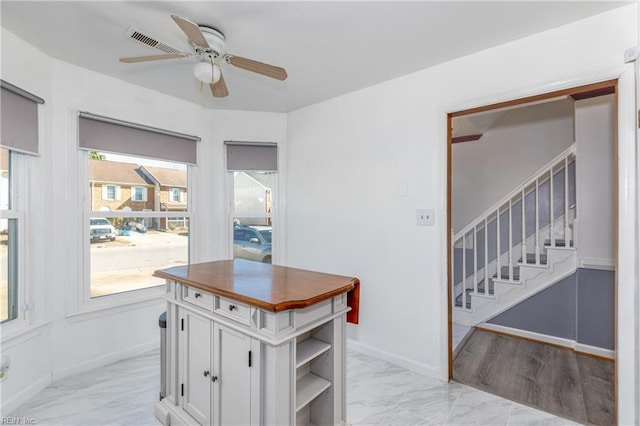 kitchen with white cabinetry and ceiling fan