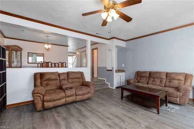 living room featuring hardwood / wood-style floors, crown molding, and ceiling fan