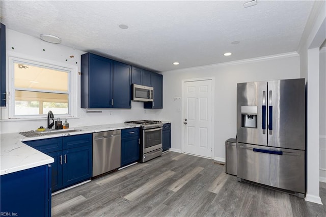 kitchen featuring blue cabinets, appliances with stainless steel finishes, sink, and light stone counters