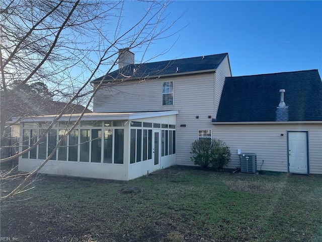 back of property with cooling unit, a yard, and a sunroom