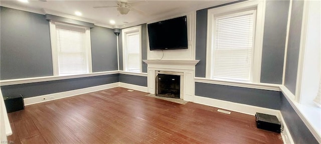 unfurnished living room with hardwood / wood-style flooring, ornamental molding, and ceiling fan