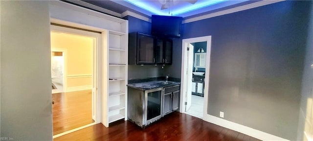 kitchen featuring dark hardwood / wood-style flooring, sink, crown molding, and ceiling fan