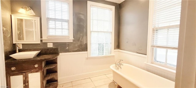 bathroom with tile patterned floors, vanity, and a washtub