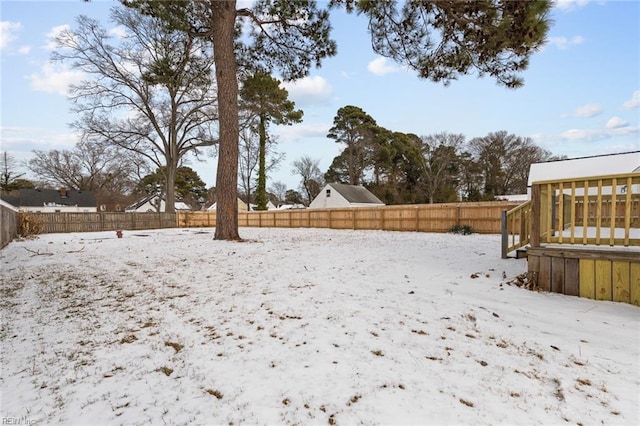 yard layered in snow with a wooden deck