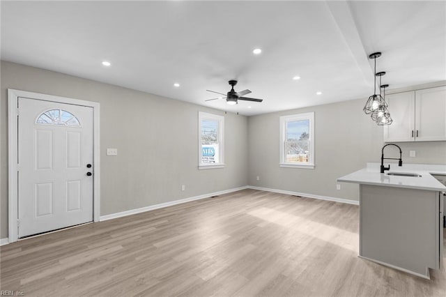 interior space with sink, light hardwood / wood-style flooring, and ceiling fan