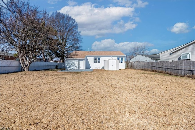 back of house with a lawn and a storage unit