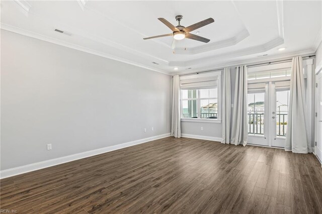 unfurnished room featuring dark hardwood / wood-style flooring, crown molding, a raised ceiling, and ceiling fan