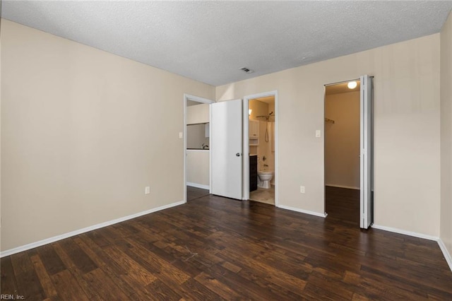 spare room featuring dark hardwood / wood-style floors and a textured ceiling