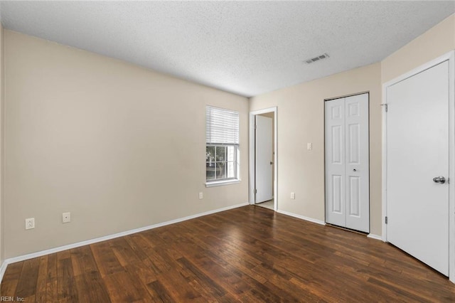 unfurnished bedroom featuring dark hardwood / wood-style floors and a textured ceiling