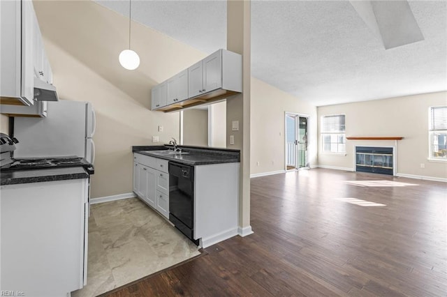 kitchen featuring lofted ceiling, sink, wood-type flooring, a textured ceiling, and dishwasher