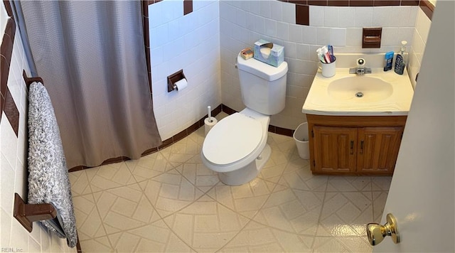 bathroom featuring walk in shower, tile patterned floors, toilet, tile walls, and vanity