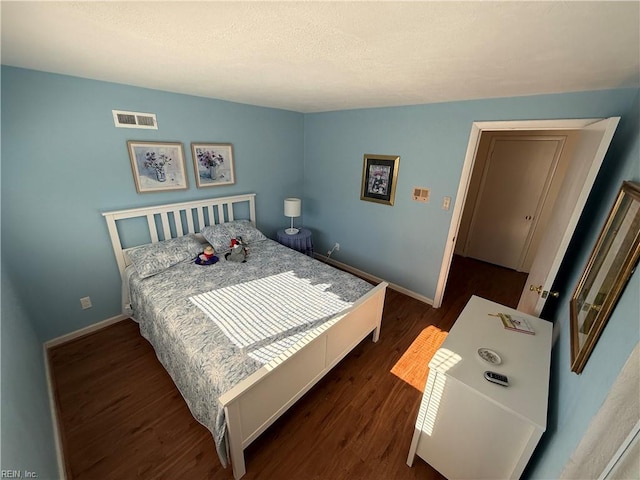 bedroom with dark hardwood / wood-style flooring