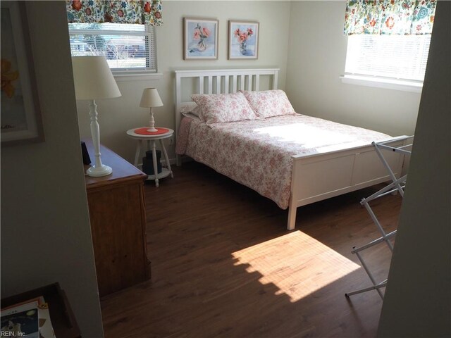 bedroom with dark hardwood / wood-style flooring