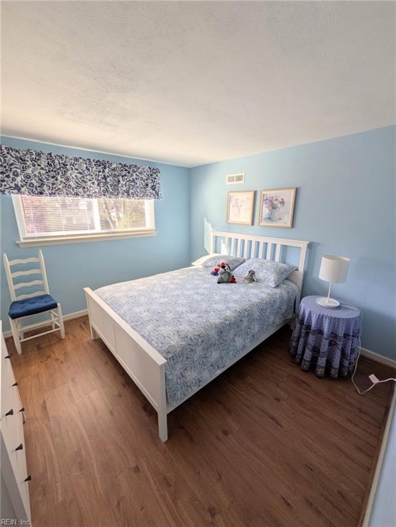 bedroom with dark hardwood / wood-style flooring