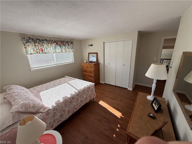 bedroom with dark hardwood / wood-style floors and a closet