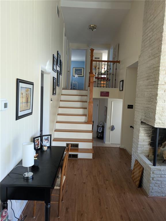 corridor with dark hardwood / wood-style flooring and a towering ceiling