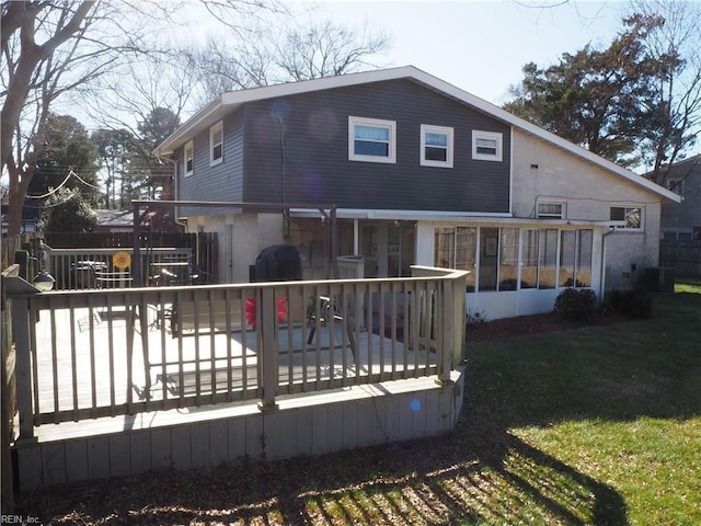 rear view of property with cooling unit, a lawn, and a deck